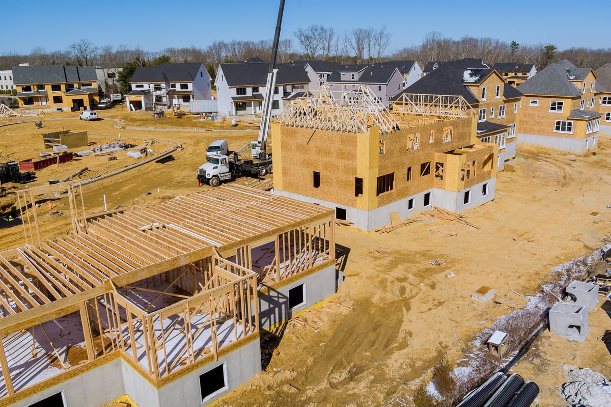 Aerial view of an active residential subdivision being developed from the ground up, with new homes and infrastructure under construction