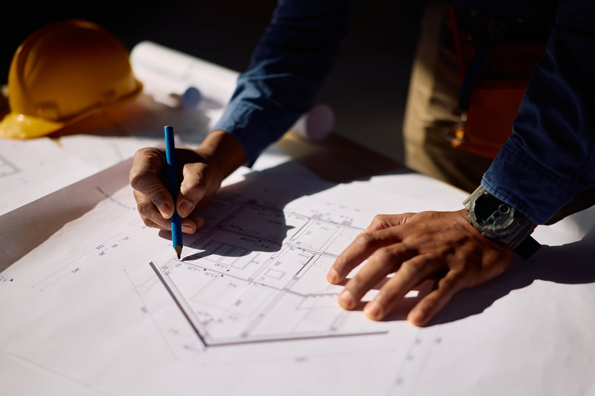 Builder reviewing development plans on site